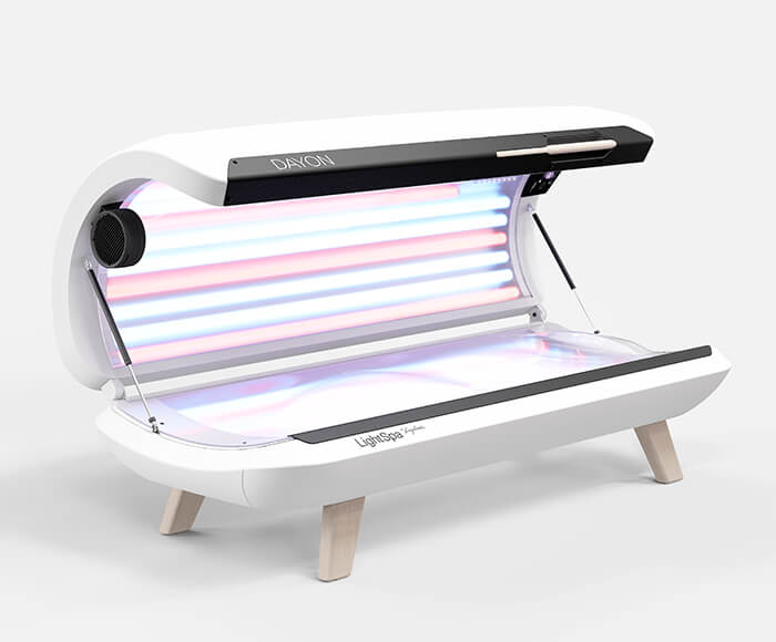 DAYON LightSpa Hybrid UV-Heimsolarium mit weißem Hintergrund, dass aufgeklappt ist, sodass man sowohl die blauen Solarium-Röhren des Deckels als auch die Liegefläche sehen kann