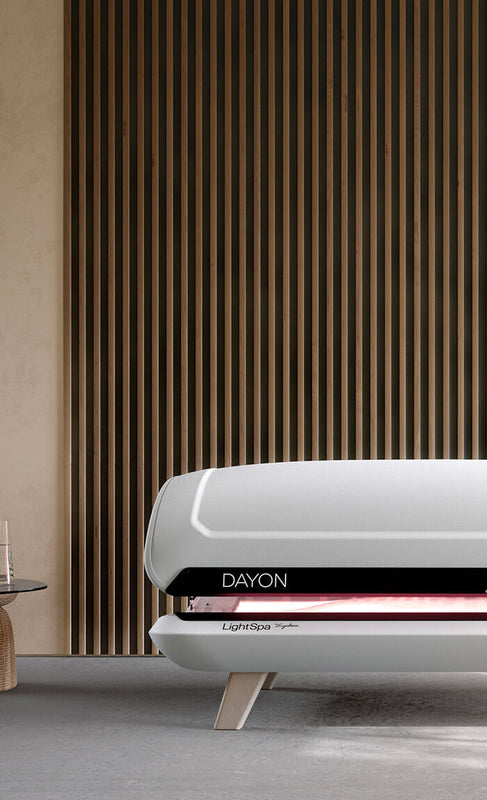 DAYON LightSpa Heimsolarium in Designer-Wohnung mit designer Holzwand und einem designer Beistelltisch links neben dem DAYON LigthSpa